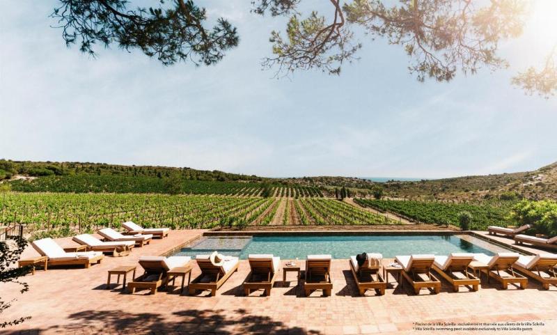 Un couple savourant un repas gastronomique avec vue sur les vignobles au restaurant hospitalet de Narbonne